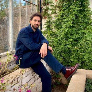 Foto de Luqman Nieto sentado en un jardín con plantas